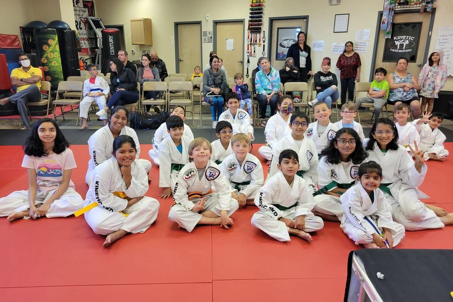 A Kinetic Taekwondo class seated on the mat with parents watching